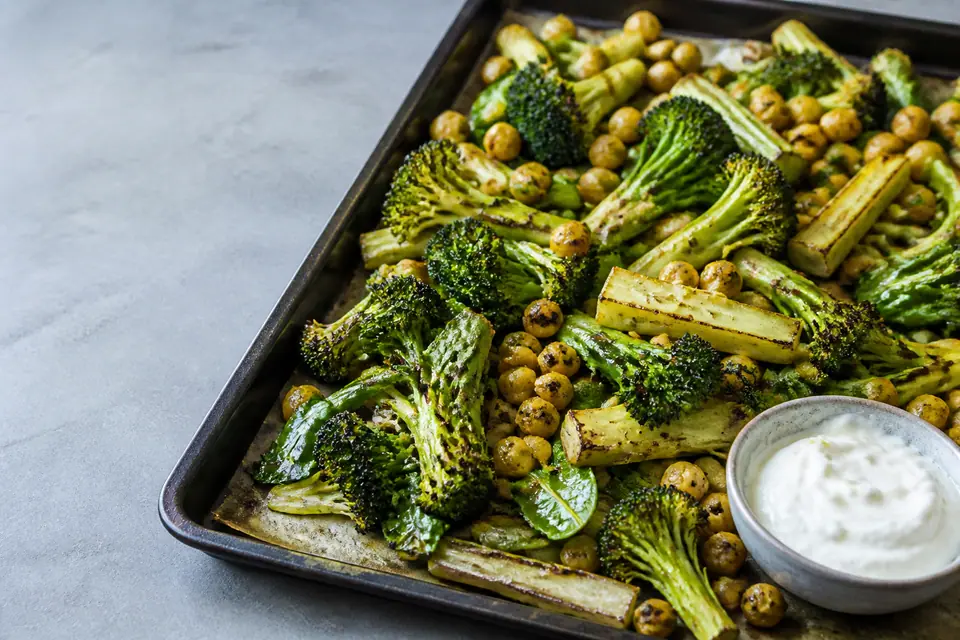 Five broccoli centred dinner components arranged around a roasted tray