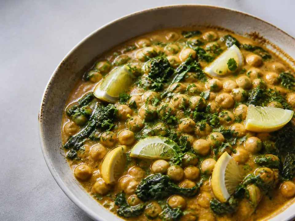 Coconut chickpea curry with greens lemon and chopped herbs