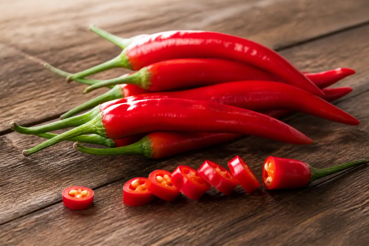 Whole dried ancho chillies with one split open to show the seeds