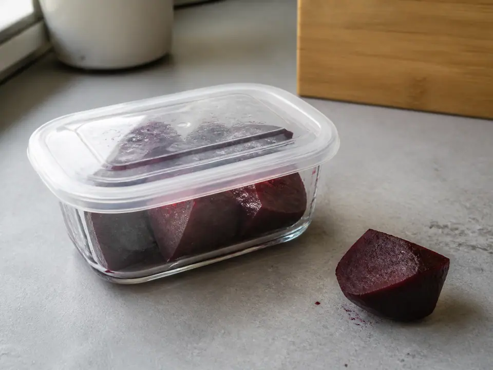 Cooked beetroot wedges stored covered beside a dry cut piece