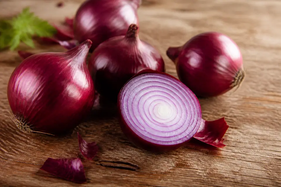 Red onions with one cut open to show vivid purple and white rings