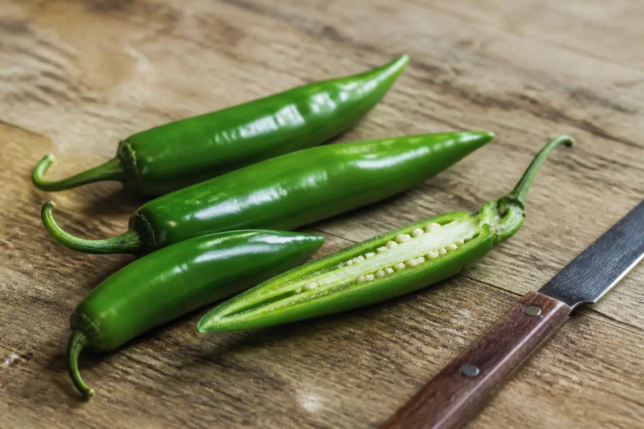 Serrano peppers with one cut lengthwise to show the seeds