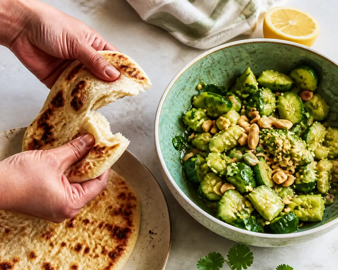 Hands preparing warm flatbread smashed cucumber and peanut salad during the make the dressing step