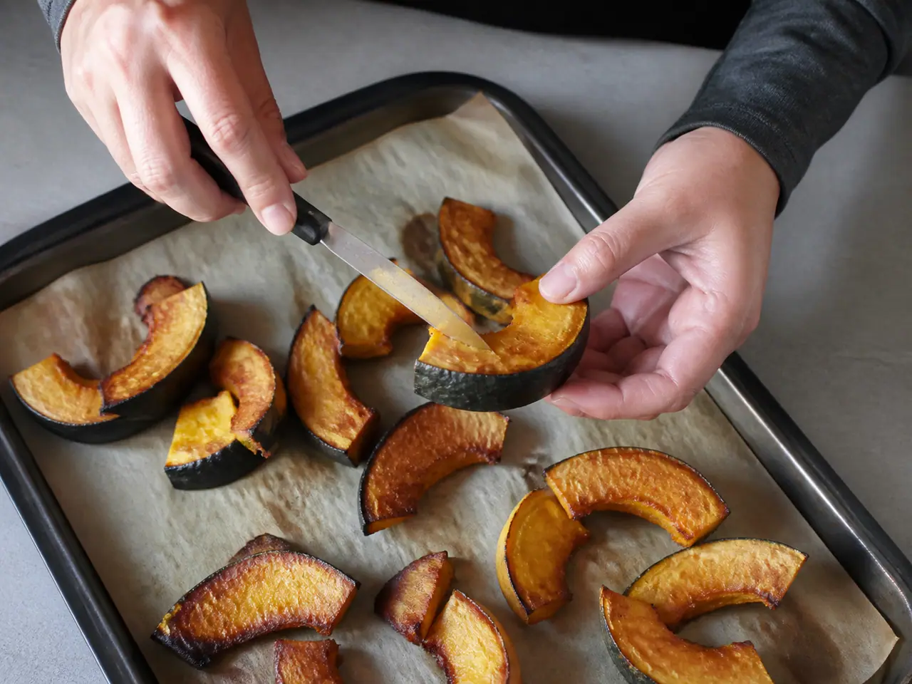 Hands testing the thickest squash piece with a small knife