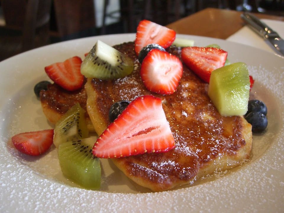 Golden zucchini fritters stacked on a plate
